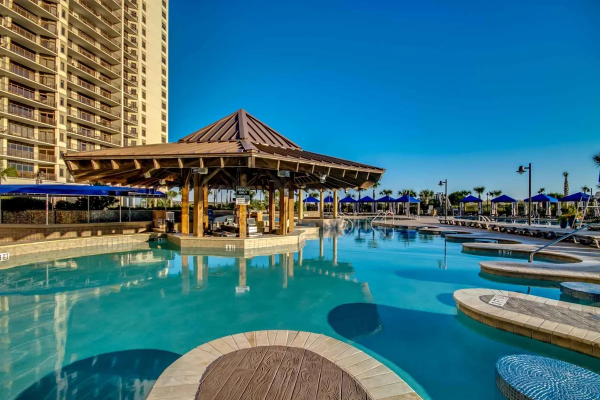 This exterior image features a sparkling pool surrounded by comfortable lounge chairs and a stylish cabana. The scene is sunlit, suggesting a fun, vibrant atmosphere perfect for relaxation and play. The pool area is spacious and inviting, with plenty of room for families to gather, swim, and socialize.